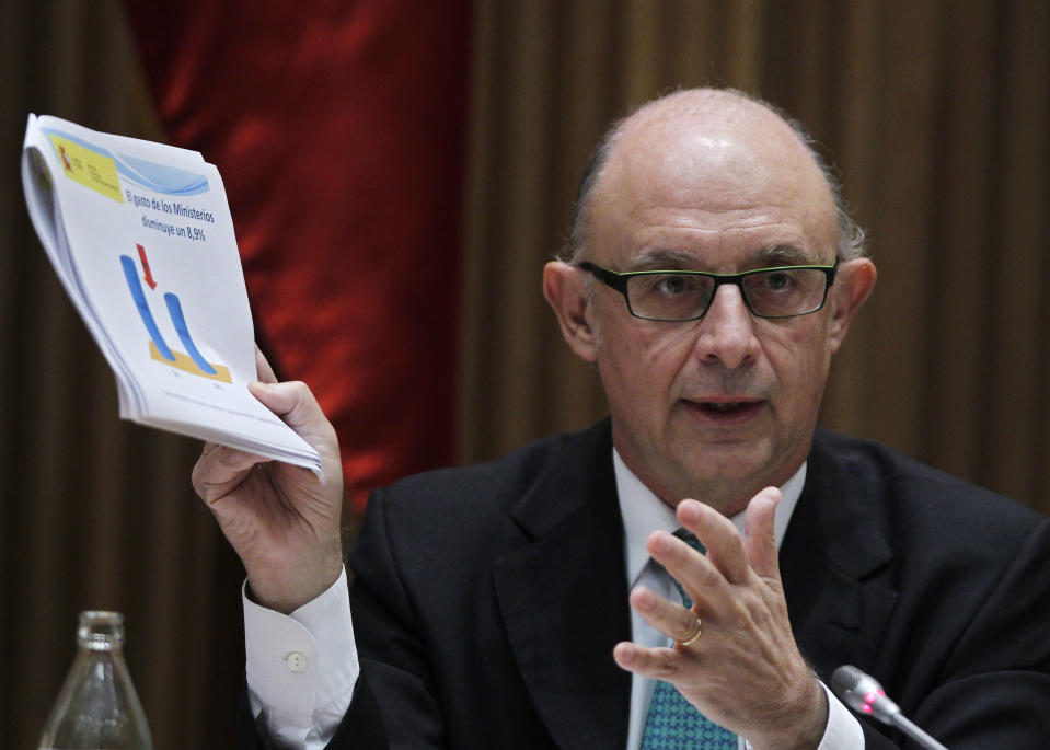 Spain's Treasury Minister Cristobal Montoro shows his papers reading "expenses of ministries get down 8.5 %" during during a news conference at Parliament in Madrid, Spain , Saturday, Sept. 29 , 2012. Spain's public debt will reach 90.5% of its gross domestic product in 2013 with new austerity budget, according to government documents. Spain also raised the forecast for this year to 85.5% from the 79.8% originally forecast. Finance Minister Cristobal Montoro spoke after presenting the 2013 draft budget that the government announced Thursday would cut overall spending by euro 40 billion ($51 billion). The budget also reduces funds available for unemployment payments by 6.3 percent, and support for Spain's royal house by 4 percent. (AP Photo/Andres Kudacki)
