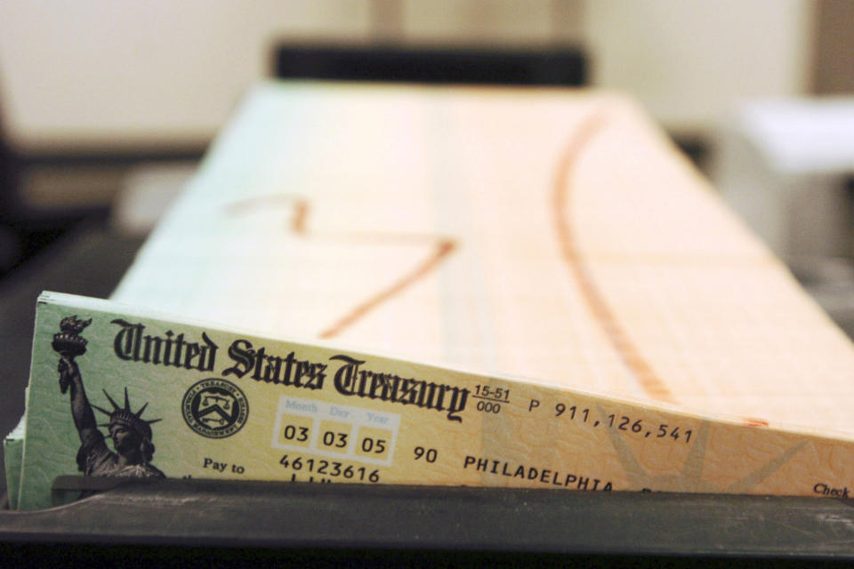 FILE - Trays of printed social security checks wait to be mailed from the U.S. Treasury's Financial Management services facility in Philadelphia on Feb. 11, 2005. On Friday, Oct. 29, 2021, The Associated Press reported on stories circulating online incorrectly claiming refugees resettled in the U.S. receive $2,125 per month from the government, while Social Security recipients only receive an average of $1,400 per month. Refugees receive no such monthly payment. (AP Photo/Bradley C. Bower, File)