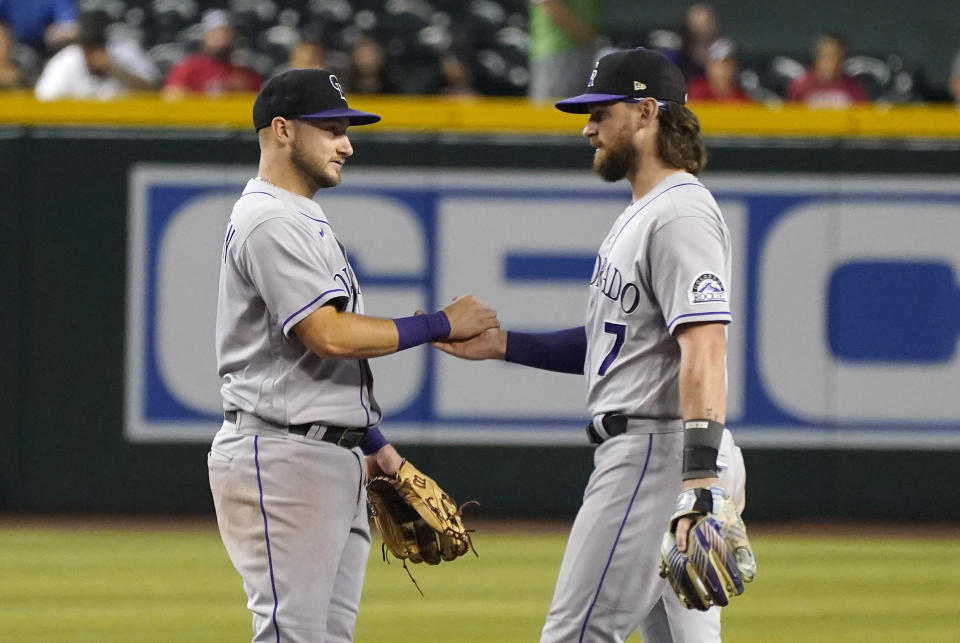 Colorado Rockies' Garrett Hampson, left, and Brendan Rodgers congratulate each other after their 3-2 win over the Arizona Diamondbacks in a baseball game, Sunday, July 10, 2022, in Phoenix. (AP Photo/Darryl Webb)