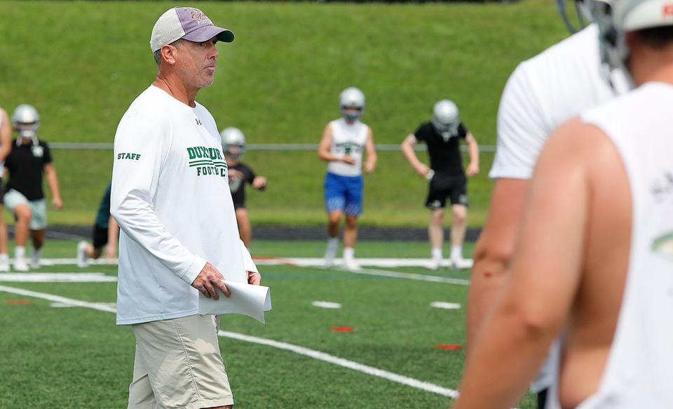 Head coach Matt Landolfi looks over his squad on the practice field. The Duxbury Dragons football squad practices for the new season on Monday, Aug. 21, 2023.