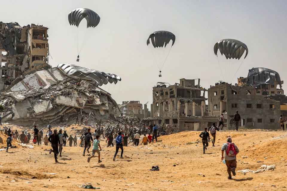 People rush to humanitarian aid packages dropped over the northern Gaza Strip on April 23, 2024. (AFP - Getty Images)