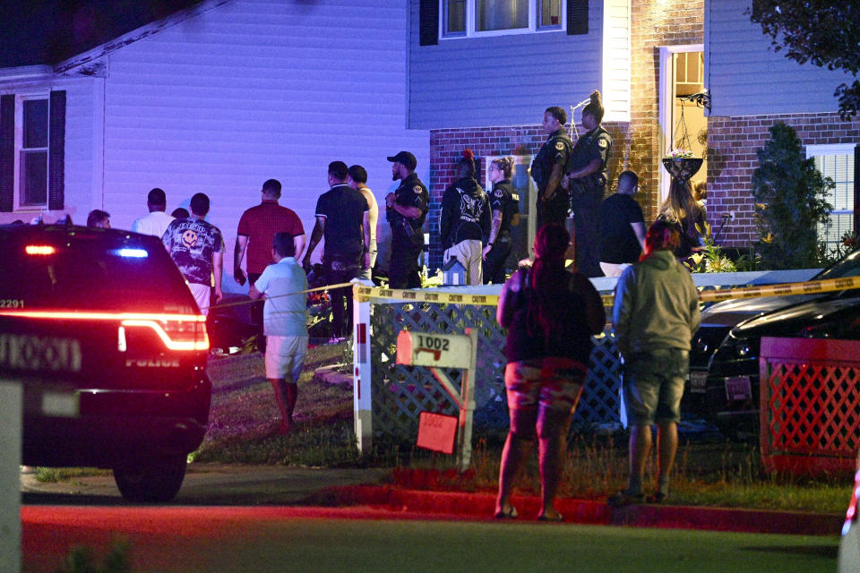 Police stand among a crowd outside a home where multiple people were shot in Annapolis, Md., on Sunday, June 11, 2023. (Jerry Jackson/The Baltimore Sun via AP)