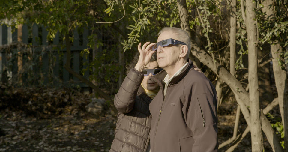 Augusto Góngora and his wife Paulina Urrutia Fernández watch an eclipse through protective shades.