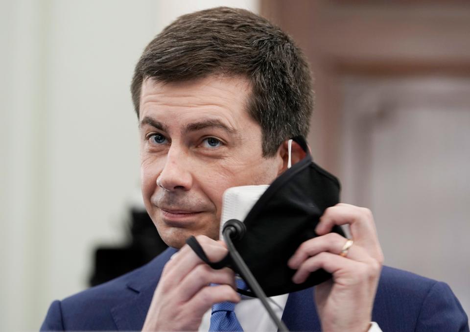 Transportation Secretary nominee Pete Buttigieg removes his two protective face masks to speak during a Senate Commerce, Science and Transportation Committee confirmation hearing on Capitol Hill, Jan. 21, 2021, in Washington. 