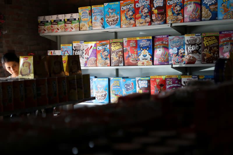 A woman searches for goods in a "bodegon" named "Mini Walmart" in Puerto Cabello