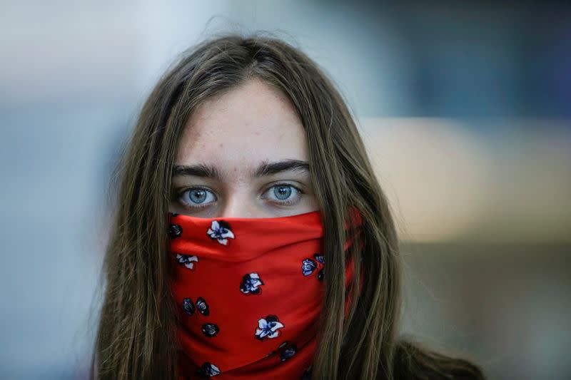 FILE PHOTO: A tourist with covered face waits to check in for her flight at Juan Santamaria International Airport , as Costa Rica tourism industry braces for coronavirus disease (COVID-19) outbreak, in Alajuela