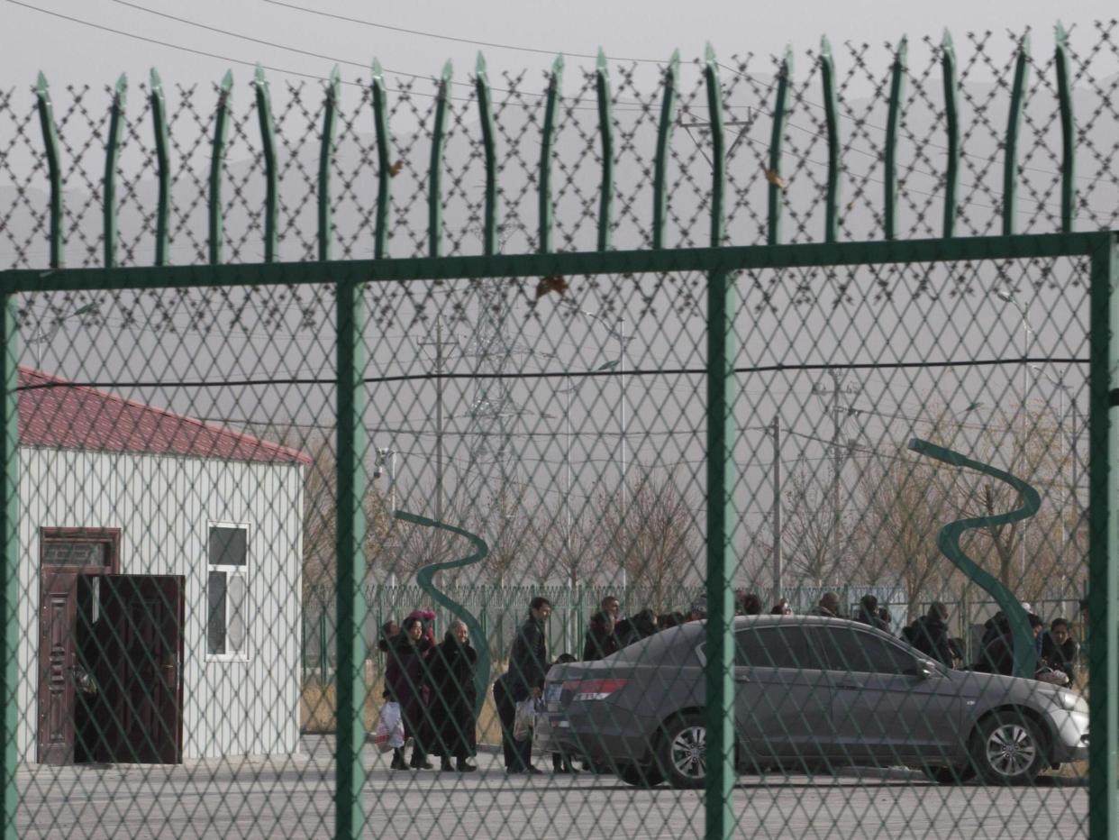 People line up at a "re-education" centre in Xinjiang province, China, in December 2018: AP Photo/Ng Han Guan, File