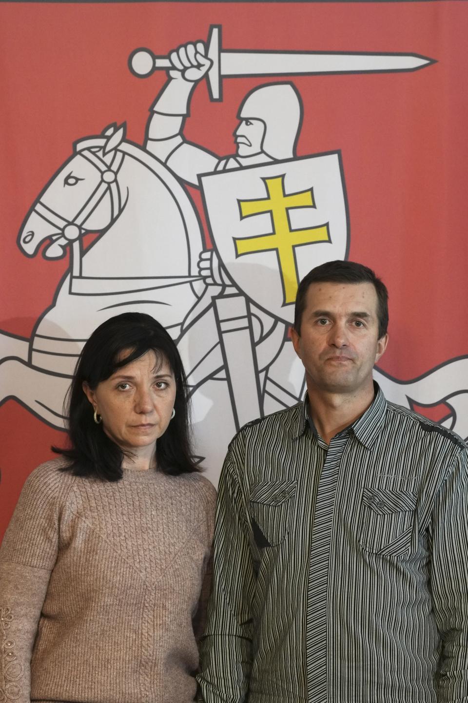 FILE - In this May 27, 2021, file photo, Natalia Pratasevich, left, and Dzmitry Pratasevich, the parents of dissident journalist Raman Pratasevich, pose in front of an old Belarusian national emblem after a news conference in Warsaw, Poland. The journalist was arrested in Minsk on Sunday, May 23, 2021, after Belarusian flight controllers told a Ryanair jetliner he was on to land in Minsk, citing a bomb threat. “I am begging you, help me free my son!” said Natalia Pratasevich. ​(AP Photo/Czarek Sokolowski, File)