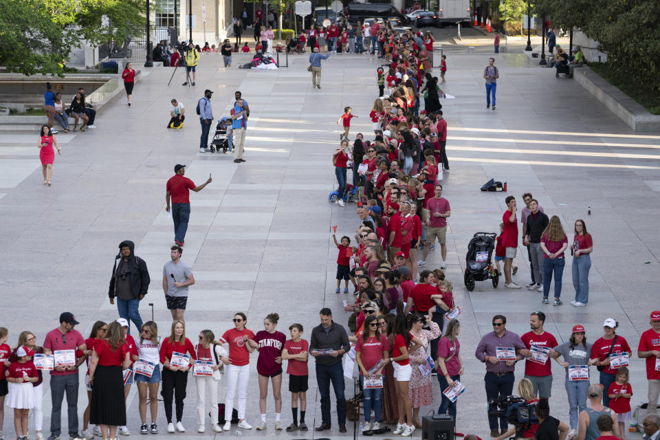 Demonstrators lock arms with each other during the "Arms Are for Hugging" protest for gun control legislation, Tuesday, April 18, 2023, in Nashville, Tenn. Participants created a human chain spreading from Monroe Carell Jr. Children's Hospital at Vanderbilt, where victims of The Covenant School shooting were taken on March 27, to the Tennessee State Capitol. (AP Photo/George Walker IV)