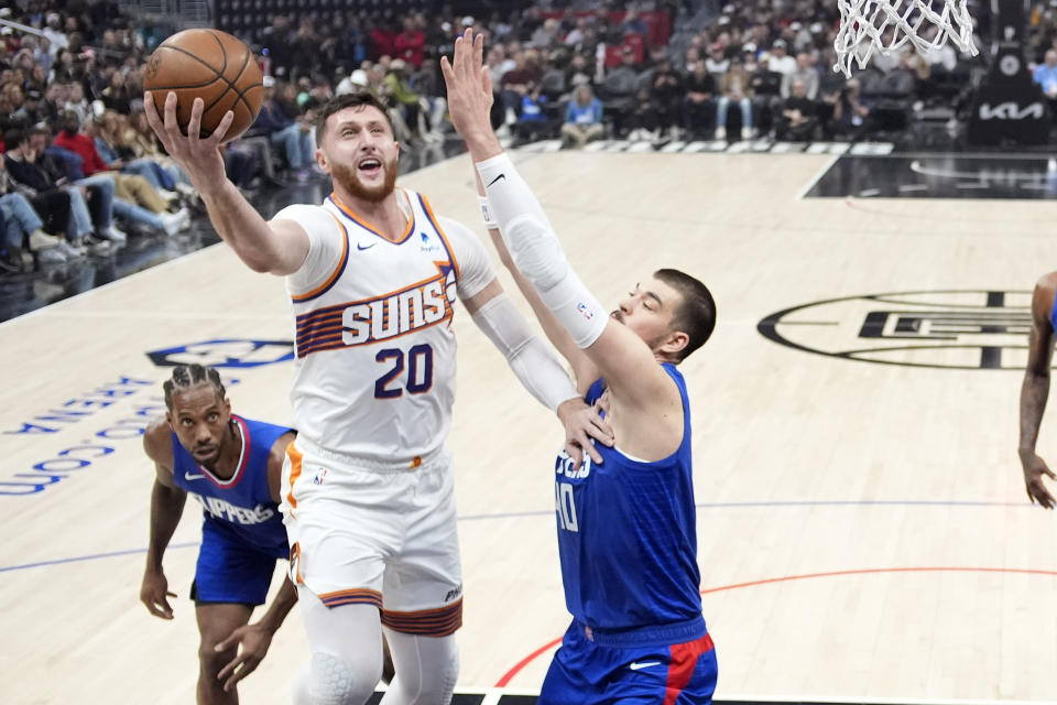 Phoenix Suns center Jusuf Nurkic, center, shoots as Los Angeles Clippers center Ivica Zubac, right, defends and forward Kawhi Leonard watches during the first half of an NBA basketball game Monday, Jan. 8, 2024, in Los Angeles. (AP Photo/Mark J. Terrill)