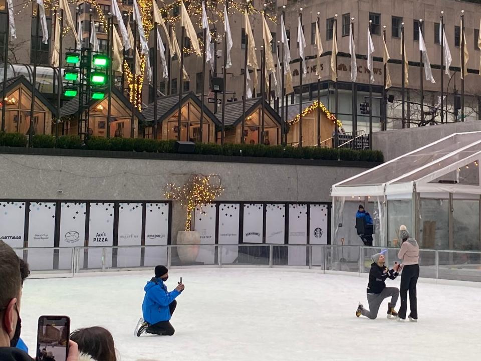 a couple getting engaged at rockefeller center