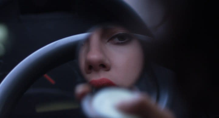 A woman looks in a compact mirror in Under the Skin.