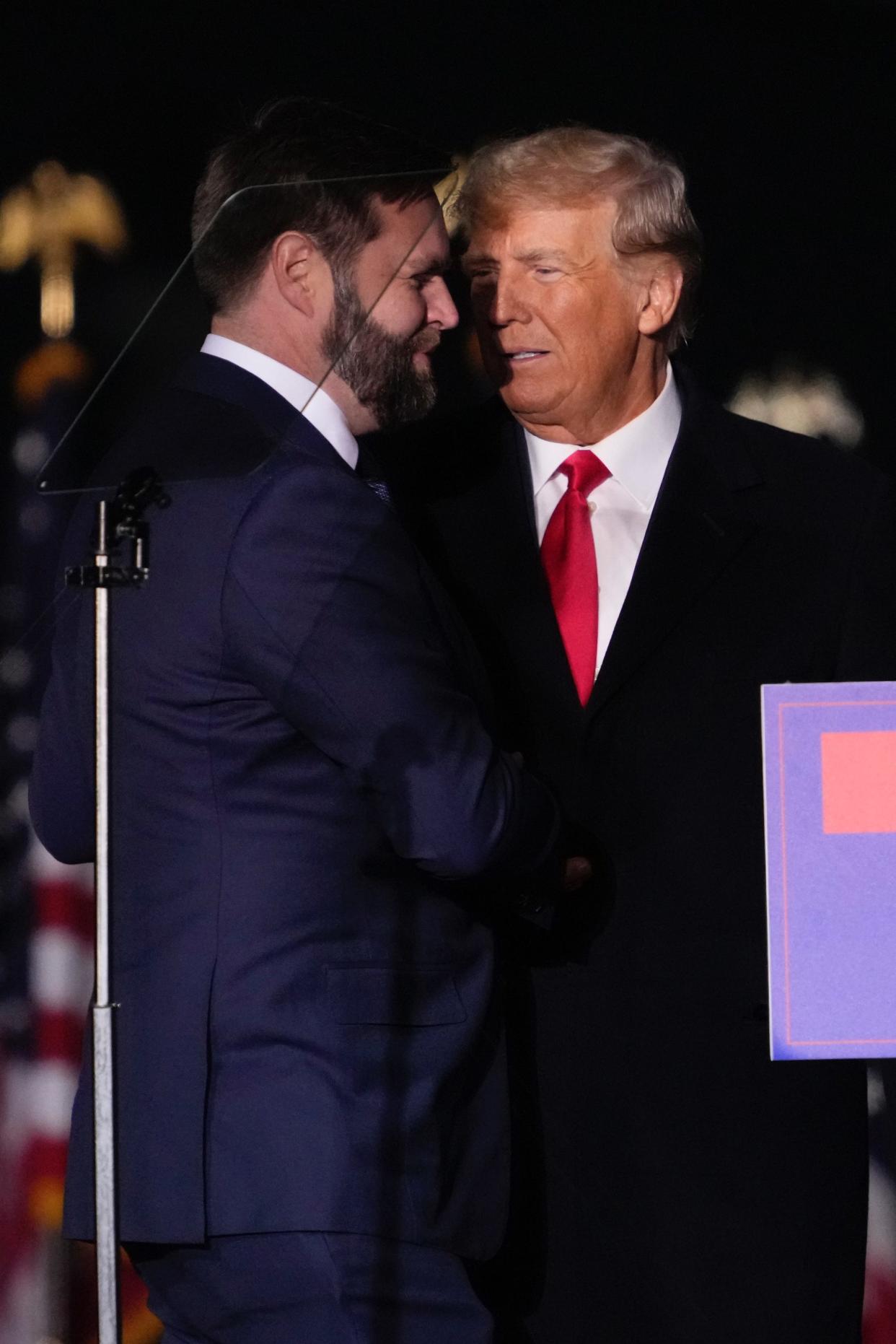 Former President Donald Trump greets U.S. Senate candidate J.D. Vance during a rally at Wright Bros. Aero Inc. at Dayton International Airport on Monday, Nov. 7, 2022, in Vandalia, Ohio.