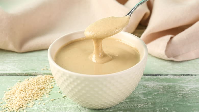 Spoonful of tahini over bowl