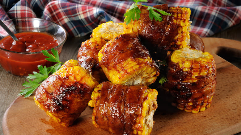 Bacon-wrapped corn on the cob with BBQ sauce