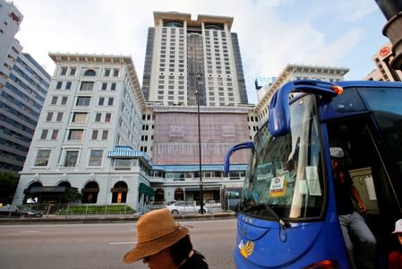 Tourists get off a bus outside The Peninsula hotel in Hong Kong