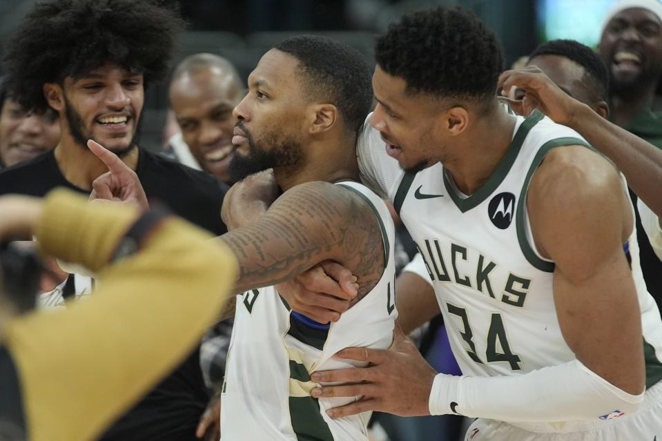 Milwaukee Bucks' Giannis Antetokounmpo hugs Damian Lillard after overtime of an NBA basketball game against the Sacramento Kings Sunday, Jan. 14, 2024, in Milwaukee. The Bucks won 143-142 in overtime. (AP Photo/Morry Gash)