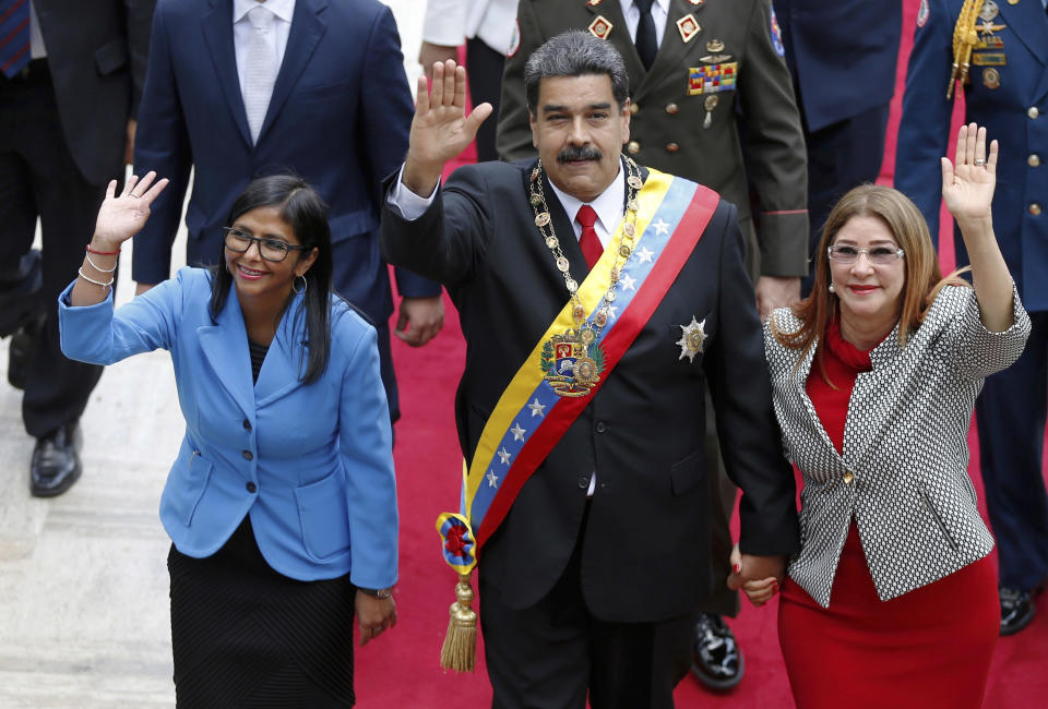 ARCHIVO - En esta foto de archivo del 24 de mayo de 2018, el presidente de Venezuela, Nicolás Maduro, la entonces presidenta de la Asamblea Nacional Constituyente, Delcy Rodríguez, a la izquierda, y la primera dama, Cilia Flores, saludan al llegar a la Asamblea Nacional en Caracas. La administración Trump impuso sanciones financieras el martes 25 de septiembre de 2018 a cuatro miembros del círculo interno de Maduro, incluida su esposa, y Rodríguez, quien ahora es vicepresidenta de la nación, por denuncias de corrupción. (AP Foto / Ariana Cubillos, Archivo)