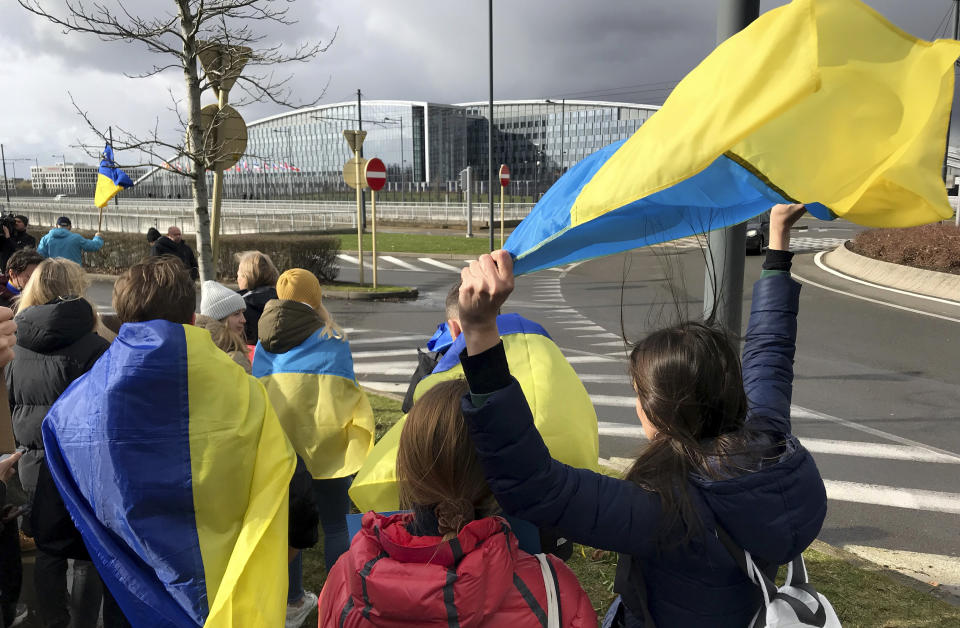 Protestors wave Ukrainian flags as they take part in a demonstration outside a NATO leaders virtual summit at NATO headquarters in Brussels, Friday, Feb. 25, 2022. U.S. President Joe Biden and his NATO counterparts will seek Friday to reassure member countries on the alliance's eastern flank that their security is guaranteed as Russia's large-scale invasion of Ukraine closes in on the capital Kyiv. (AP Photo/Mark Carlson)