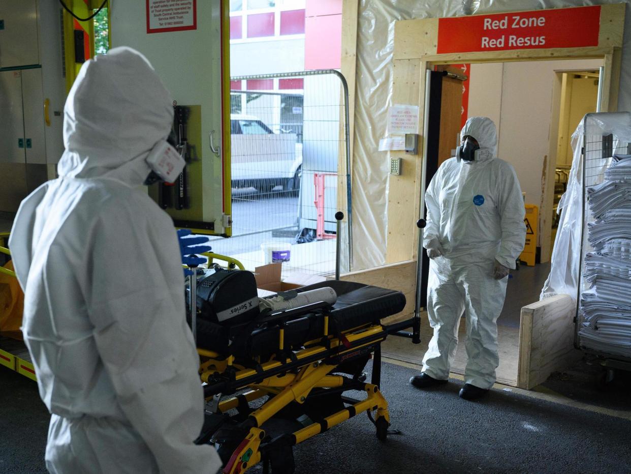 An emergency car assistant and a paramedic wait to safely remove their PPE3-level clothing in the ambulance bay of a hospital in Southampton amid the coronavirus pandemic: LEON NEAL/POOL/AFP via Getty Images