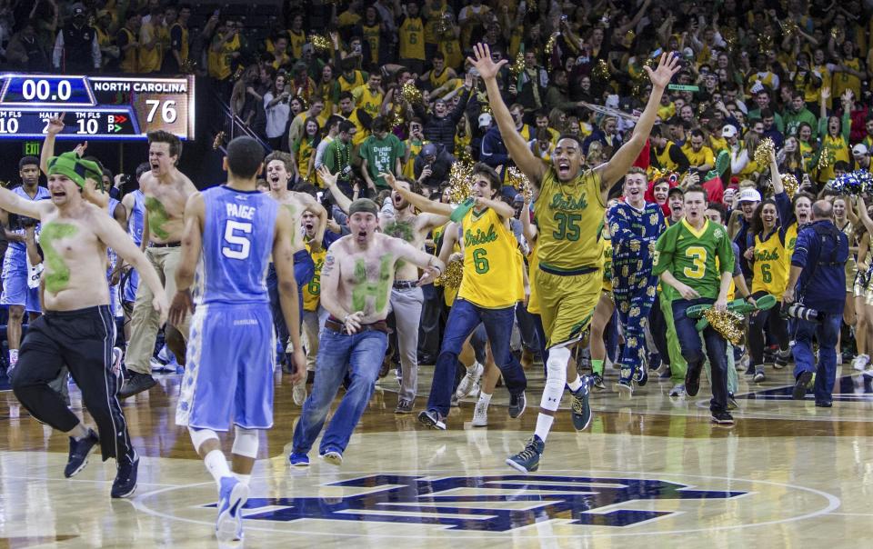 FILE - Notre Dame players and fans storm the court following Notre Dame's 80-76 win against North Carolina in an NCAA college basketball game Saturday, Feb. 6, 2016, in South Bend, Ind. Recent incidents in college basketball have underscored the potential dangers that come from jubilant fans storming the court after the game comes to an end. Finding a solution is proving to be a challenge. (AP Photo/Robert Franklin, File)