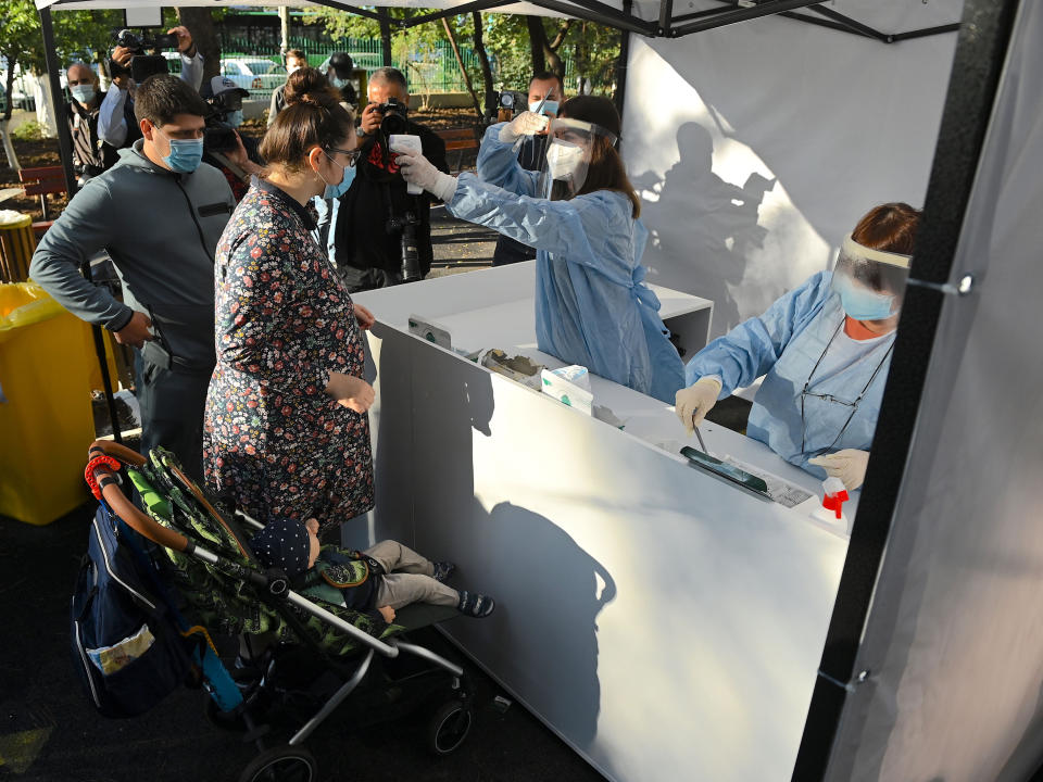 People get their body temperature measured as they enter a polling station in BucharestAFP via Getty Images