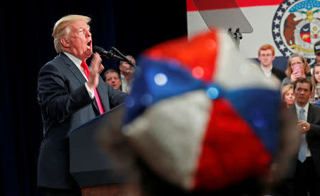 A woman wearing a red white and blue hat listens as U.S. President Donald Trump speaks about tax reform legislation during a visit to St. Louis, Missouri, U.S. November 29, 2017. REUTERS/Kevin Lamarque