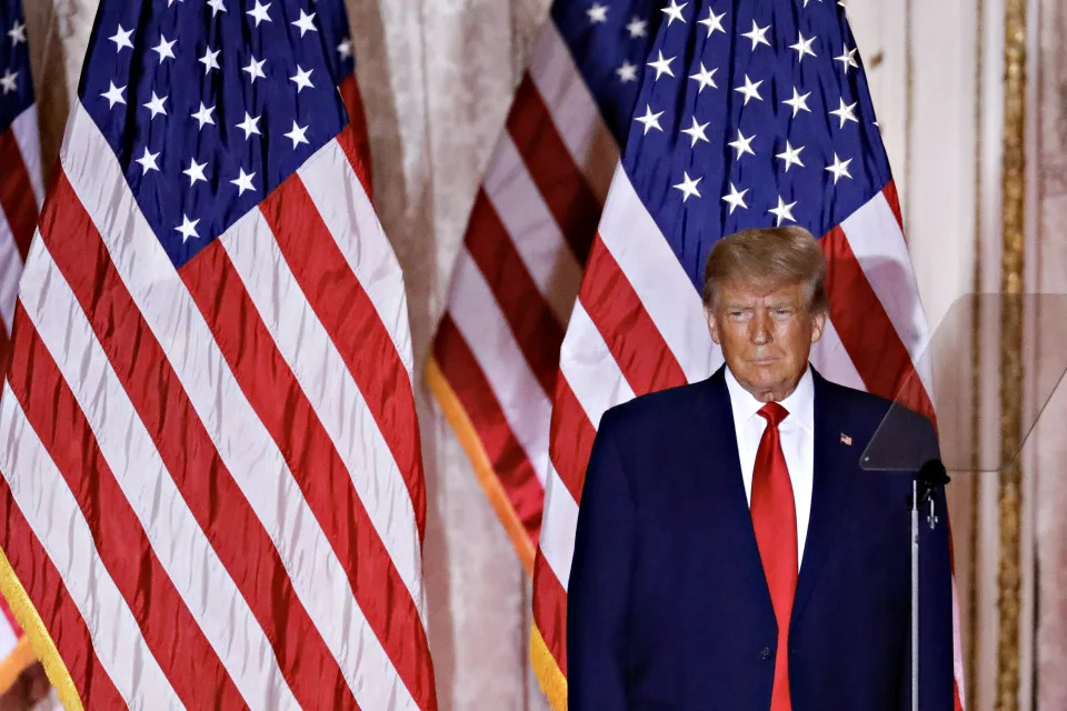 Former President Donald Trump, in front of American flags, arrives to speak at Mar-a-Lago.