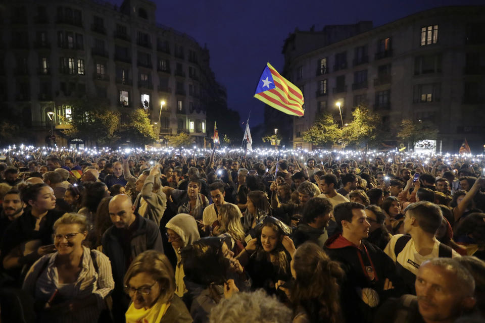 People hold up their phones with the torches switched on during a Catalan pro-independence protest in Barcelona, Spain, Sunday, Oct. 20, 2019. Barcelona and the rest of the restive Spanish region of Catalonia are reeling from several days of violent protests for the sentencing of 12 separatist leaders to lengthy prison sentences.Riots have broken out at nightfall following huge peaceful protests each day since Monday's Supreme Court verdict. (AP Photo/Ben Curtis)