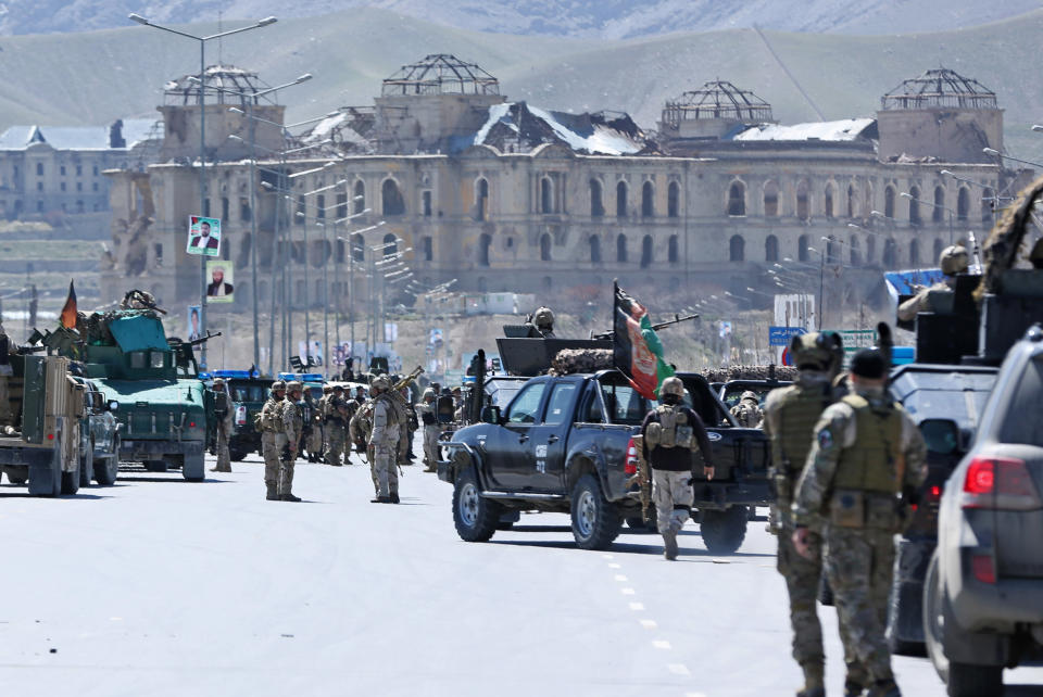 Afghan security forces walk near the site of a gun battle with insurgents in an Independent Elections Commission (IEC) office in Kabul, Afghanistan, Tuesday, March 25, 2014. Gunmen stormed into the building, trapping dozens of employees inside and killing many people. A candidate for a seat on a provincial council was among those killed, along with an election worker, a civilian and a policeman. (AP Photo/Massoud Hossaini)