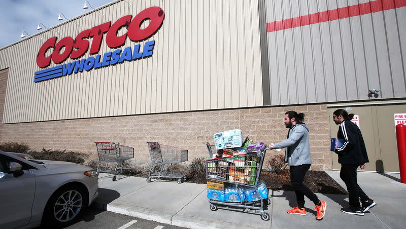 Two shoppers take water, toilet tissue and other items to their car as they and other shoppers at the Lehi Costco on Tuesday, March 3, 2020.