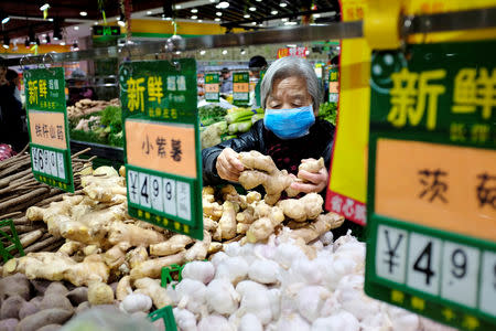 A resident selects ginger at a supermarket in Beijing, China January 2, 2018. REUTERS/Jason Lee/Files