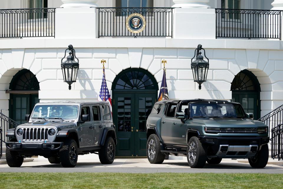 Two electric vehicles are parked on the South Lawn of the White House before President Joe Biden speaks on Aug. 5, 2021, at an event on clean cars and trucks.