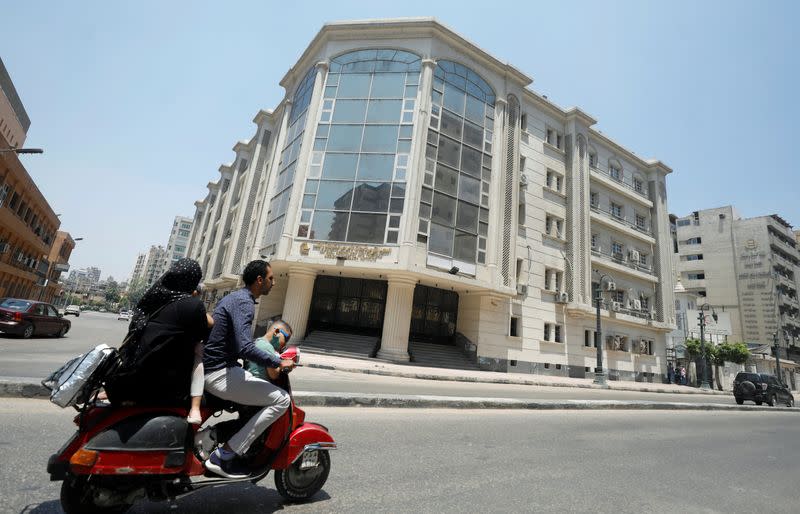 A family rides a motorbike in front of National Hepatology and Tropical Medicine Research Institute amid concerns about the spread of the coronavirus disease (COVID-19), in Cairo