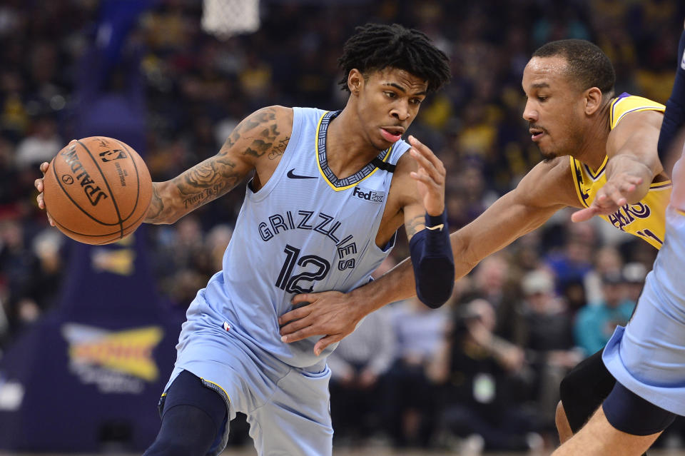 Memphis Grizzlies guard Ja Morant (12) handles the ball against Los Angeles Lakers guard Avery Bradley (11) in the first half of an NBA basketball game Saturday, Feb. 29, 2020, in Memphis, Tenn. (AP Photo/Brandon Dill)