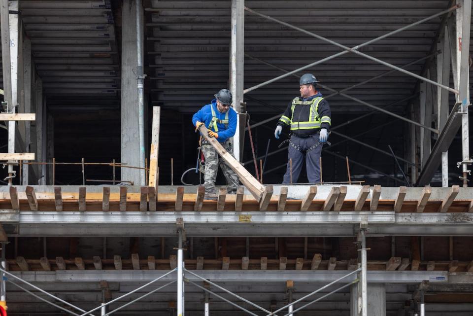 Workers are shown at a new multi-story apartment building under construction in Halifax. 
