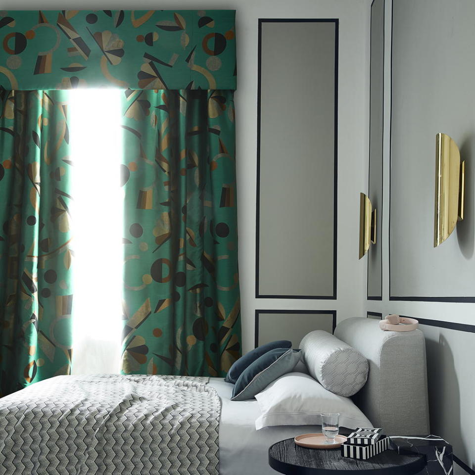 bedroom with grey walls and geometric pattern curtains