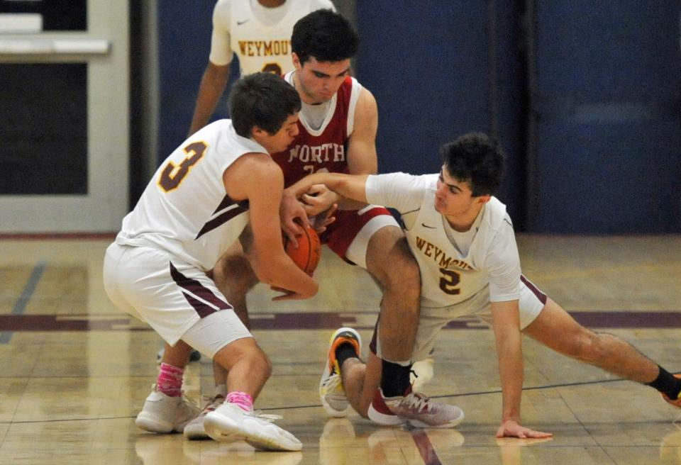 Battling for the ball are Weymouth's Alex Pineiro, left, and teammate Nick Neary, right, and North Attleborough's Chace Frisoli, center, during boys basketball action at Weymouth High School, Monday, Monday, Feb. 20, 2023.