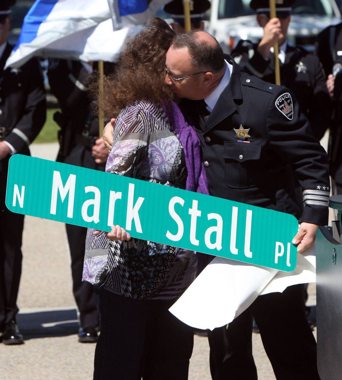 Boise Police Department Deputy Chief Jim Kerns presents Mark Stall’s mother, Nancy Stall, a street sign bearing Stall’s name .