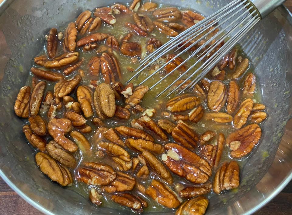 pecans and pecan pie filling in a bow with a whisk