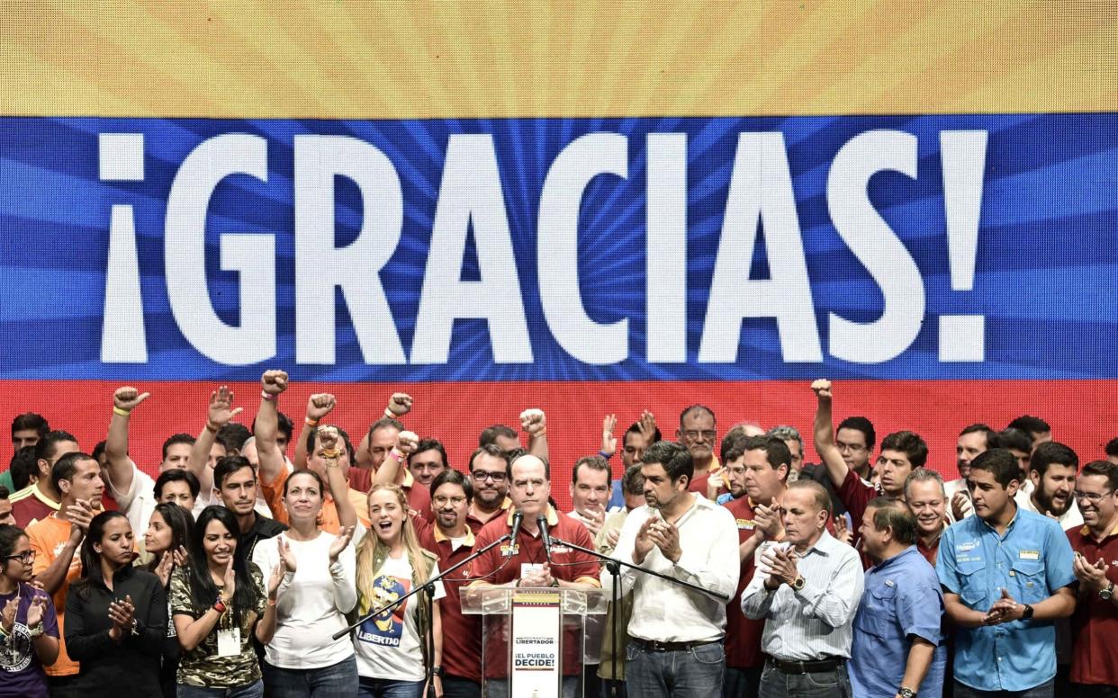 Julio Borges, president of Venezuela's National Assembly, center, gives a speech as opposition leaders celebrate the result of a symbolic Venezuelan plebiscite. - Bloomberg