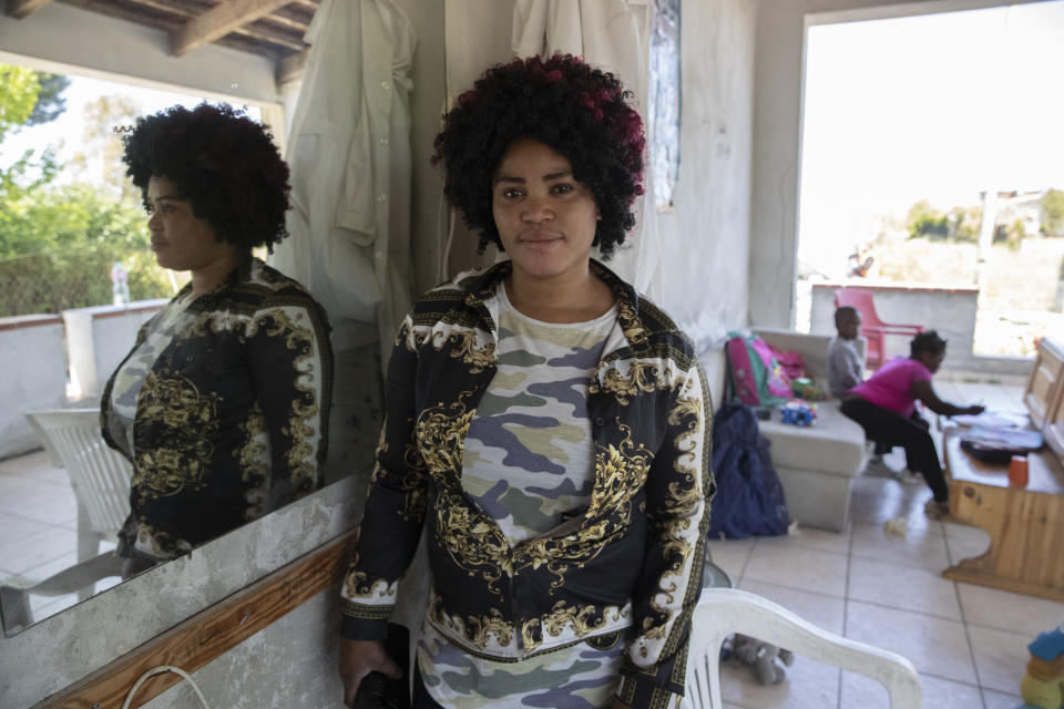 In this photo taken on Monday, April 27, 2020, Mary Sado Ofori, 33 year-old from Nigeria poses for a photo outside her home in Castel Volturno, near Naples, Southern Italy. Mary Sado Ofori has three children, including a little baby. Normally she works as a hairdresser doing weaves and braids for other women, bringing in a little money. Now she cannot work. They are known as “the invisibles,” the undocumented African migrants who, even before the coronavirus outbreak plunged Italy into crisis, barely scraped by as day laborers, prostitutes and seasonal farm hands. Locked down for two months in their overcrowded apartments, their hand-to-mouth existence has grown even more precarious with no work, no food and no hope. (AP Photo/Alessandra Tarantino)