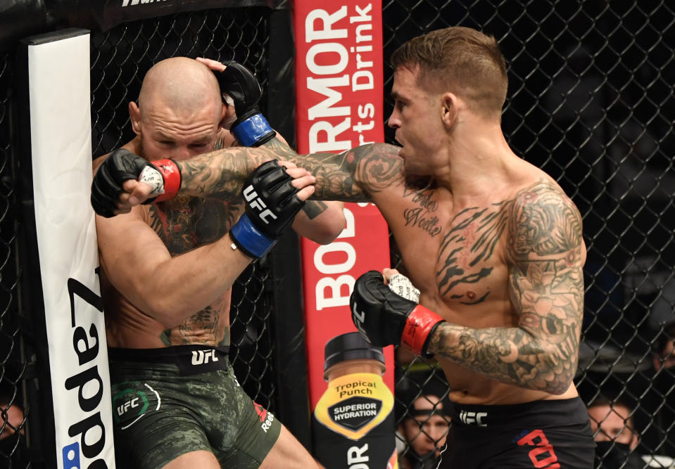 Dustin Poirier (left) punches Conor McGregor of Ireland in a lightweight fight during the UFC 257 event inside Etihad Arena in Abu Dhabi.