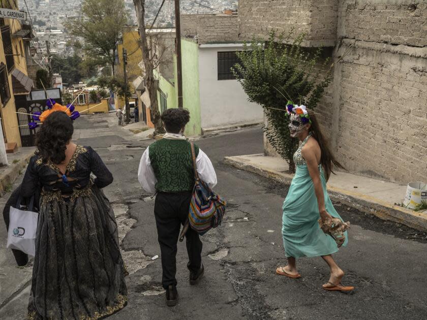 Three people walk on a street