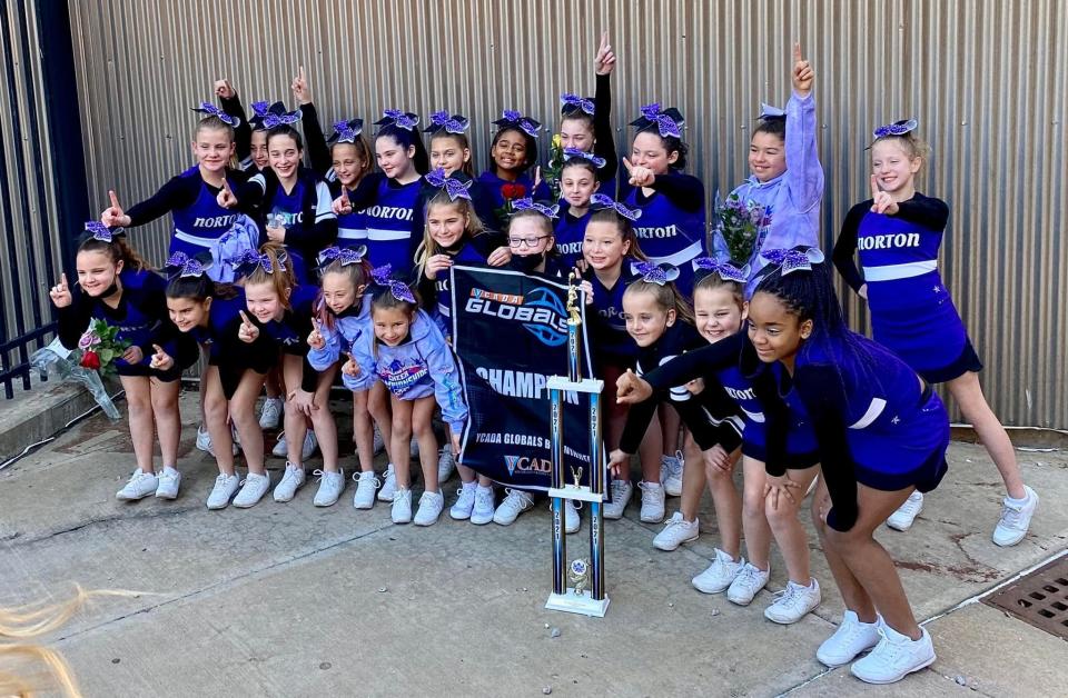 The 2021 Norton Lady Junior Lancers 10U cheerleading squad with their New England Championship banner and trophy.