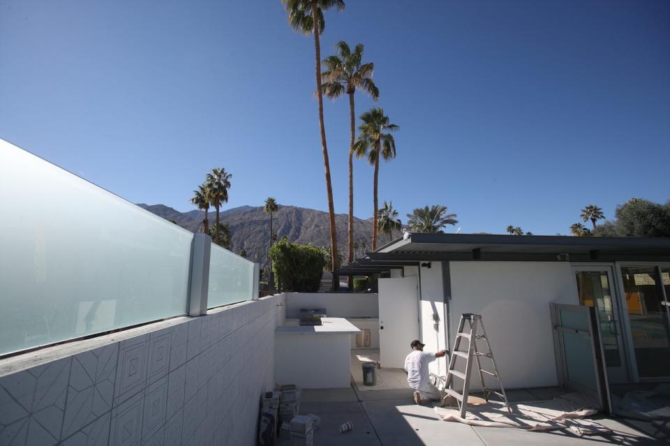 Candido Galeno of Glenn Strickland Painting applies a fresh coat of paint to the trim of the Limon property in preparation for Modernism Week in Palm Springs, Calif., on Thursday, Feb. 10, 2022.