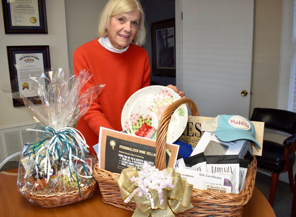 Ottawa County Community Foundation Trustee Mary Coffee displays some of the generous business donations received for the Open House and OCCF’s Virtual Auction Fundraiser.