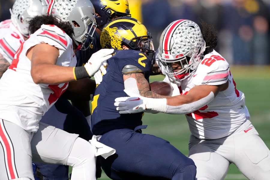 Michigan running back Blake Corum (2) is stopped by Ohio State linebacker Steele Chambers (22) during the first half of an NCAA college football game, Saturday, Nov. 25, 2023, in Ann Arbor, Mich. (AP Photo/Carlos Osorio)