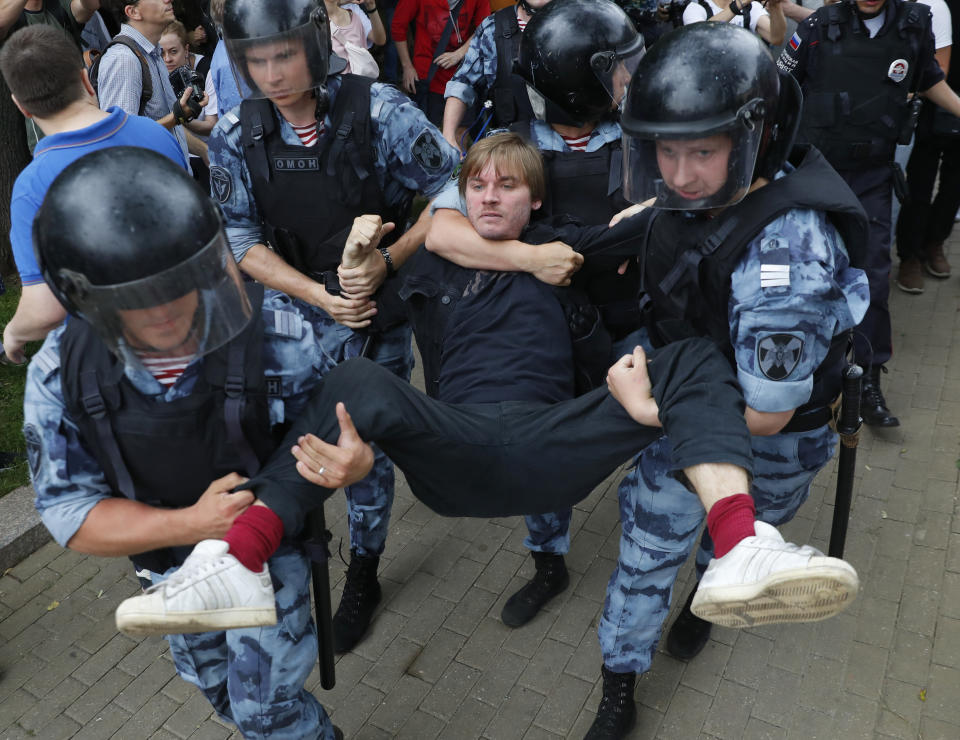Police officers detain a protester during a march in Moscow, Russia, Wednesday, June 12, 2019. Police and hundreds of demonstrators are facing off in central Moscow at an unauthorized march against police abuse in the wake of the high-profile detention of a Russian journalist. More than 20 demonstrators have been detained, according to monitoring group. (AP Photo/Pavel Golovkin)