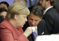 German Chancellor Angela Merkel talks with Italian Prime Minister Giuseppe Conte over a coffee at the annual meeting of the World Economic Forum in Davos, Switzerland, Wednesday, Jan. 23, 2019. (AP Photo/Markus Schreiber)